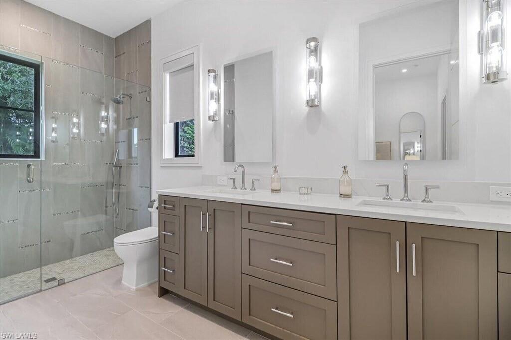 1546 Mandarin Road Naples, FL 34102 - Photo 25 of 48 Bathroom featuring toilet, a shower with shower door, vanity, and a wealth of natural light