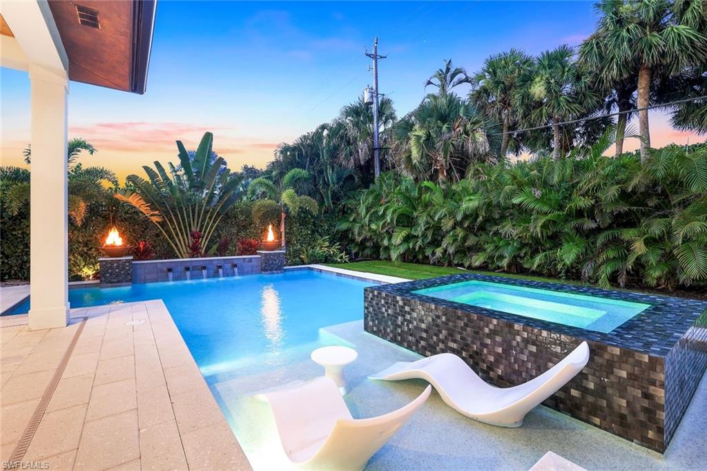 1546 Mandarin Road Naples, FL 34102 - Photo 47 of 48 Pool at dusk featuring a patio area and a pool with connected hot tub