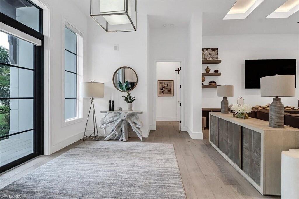 1546 Mandarin Road Naples, FL 34102 - Photo 7 of 48 Hallway featuring light hardwood / wood-style floors and a skylight