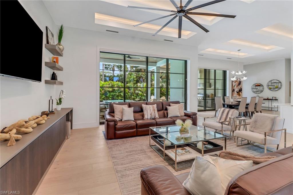 1546 Mandarin Road Naples, FL 34102 - Photo 10 of 48 Living room featuring light wood-type flooring and ceiling fan with notable chandelier