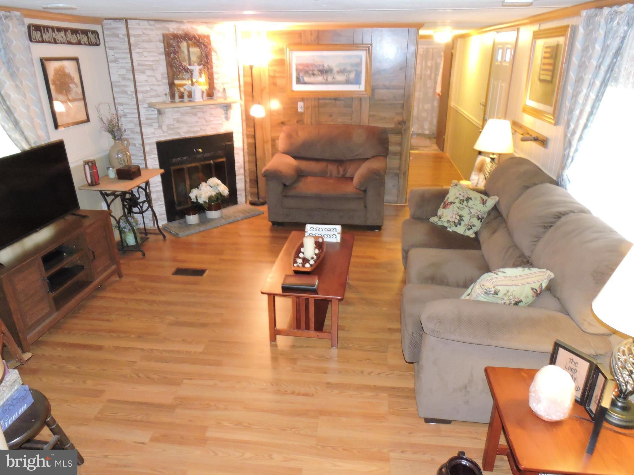 Large living rm w/laminate floors, a fireplace and