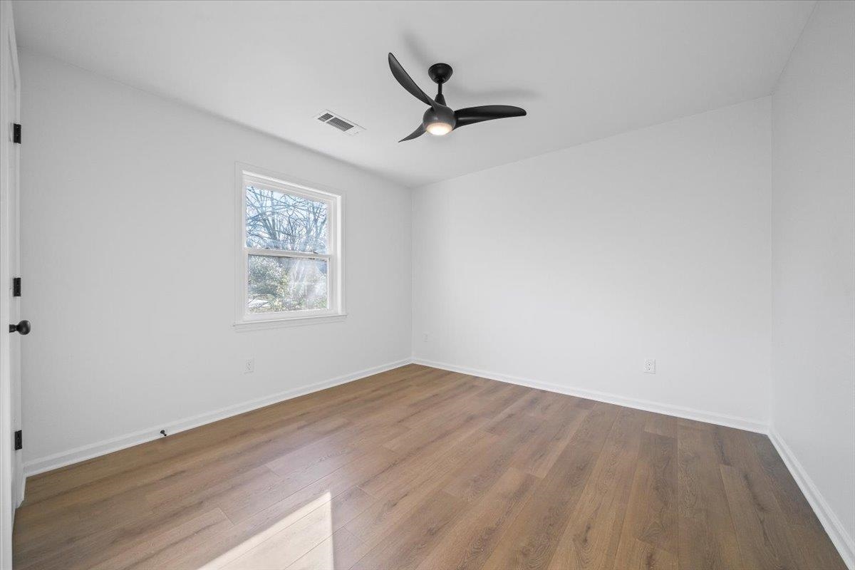 1676 Miller Farms Road Germantown, TN 38138 - Photo 21 of 37 Room featuring wood-finish flooring, a contemporary ceiling fan with integrated lighting, a single window, and a white door with matte black hardware