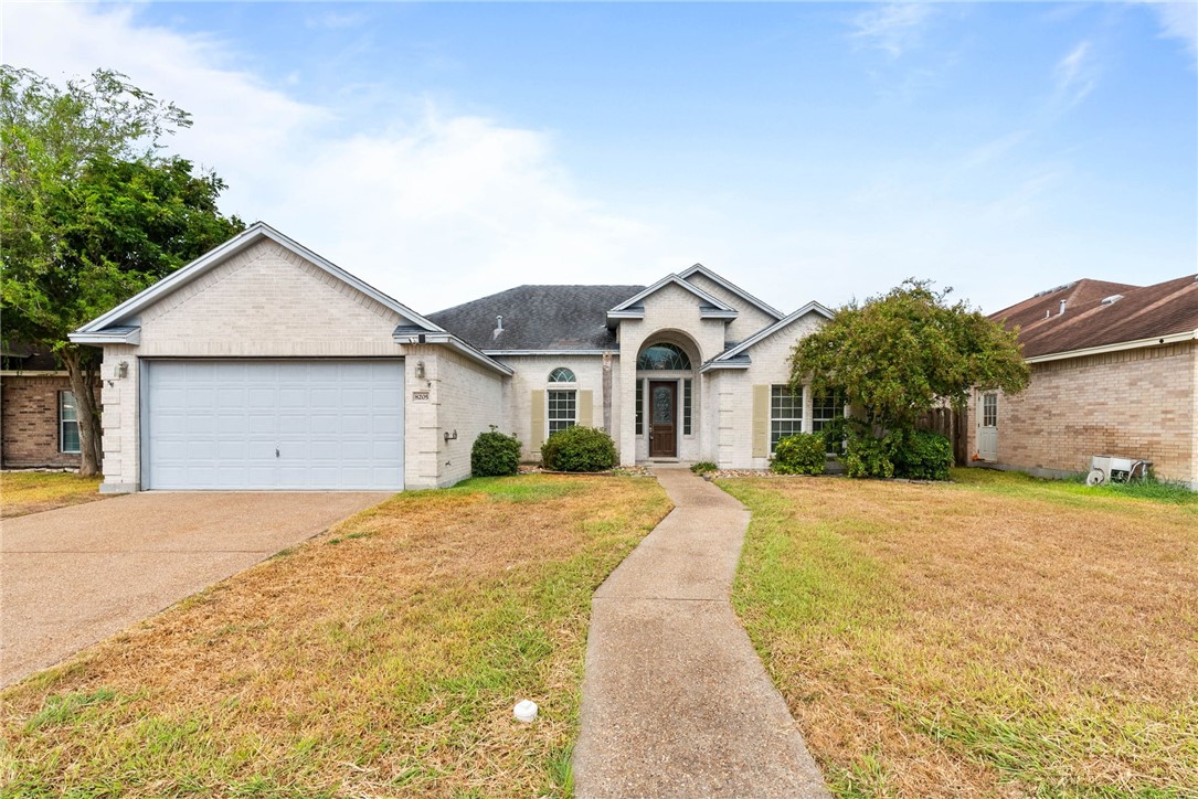 8205 Tango Circle Corpus Christi, TX 78414 - Photo 1 of 22 a view of yellow house with a yard and large tree