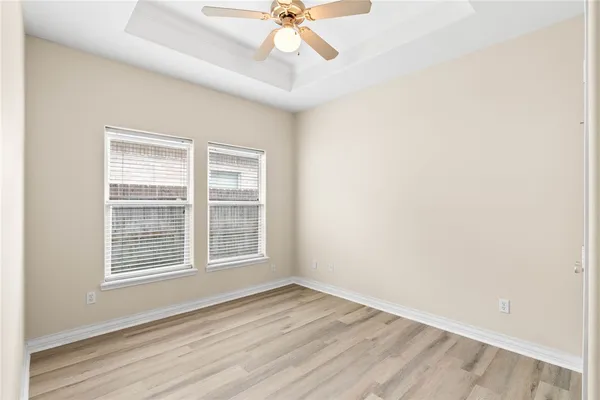 an empty room with a window and a ceiling fan