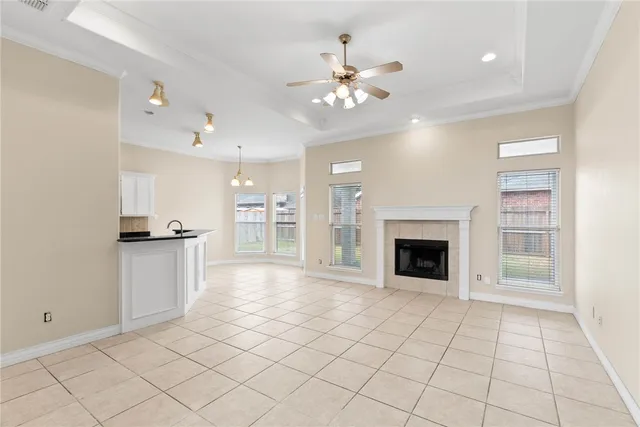 a view of an empty room with kitchen and a window