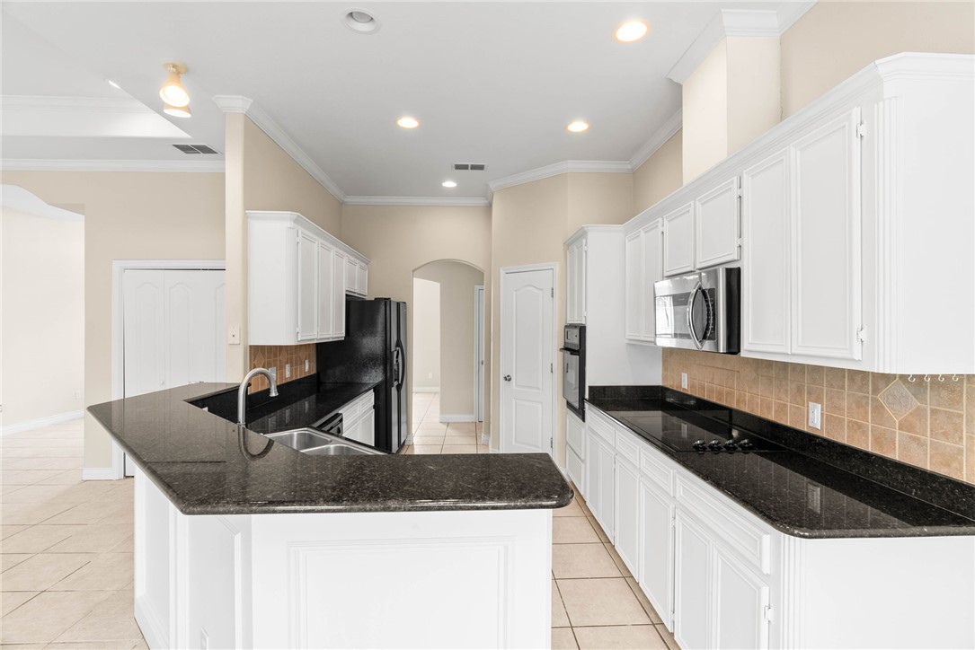 8205 Tango Circle Corpus Christi, TX 78414 - Photo 7 of 22 a kitchen with granite countertop a sink a stove and refrigerator
