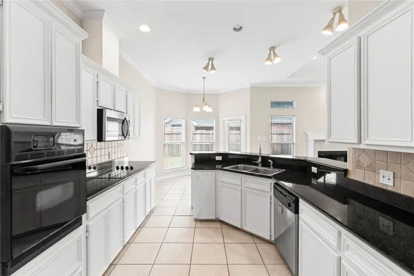 a kitchen with stainless steel appliances granite countertop a sink stove cabinets and a counter space