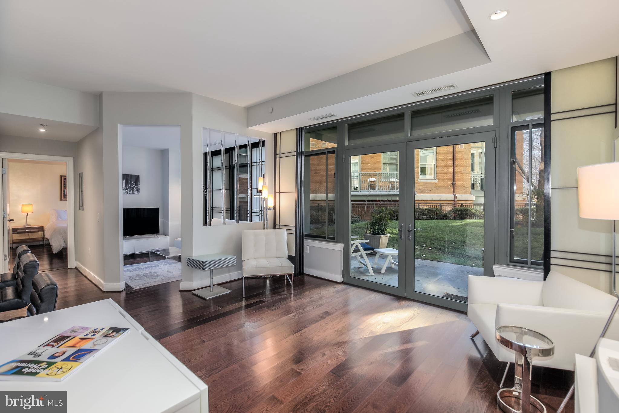 2425 L Street Northwest, Unit 211 Washington, DC 20037 - Photo 1 of 43 a living room with furniture and a large window with outer view
