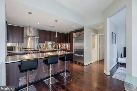 a kitchen with stainless steel appliances granite countertop a refrigerator and a stove top oven