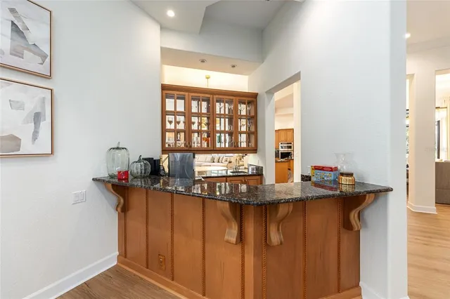 a view of a living room and kitchen with furniture wooden floor and windows