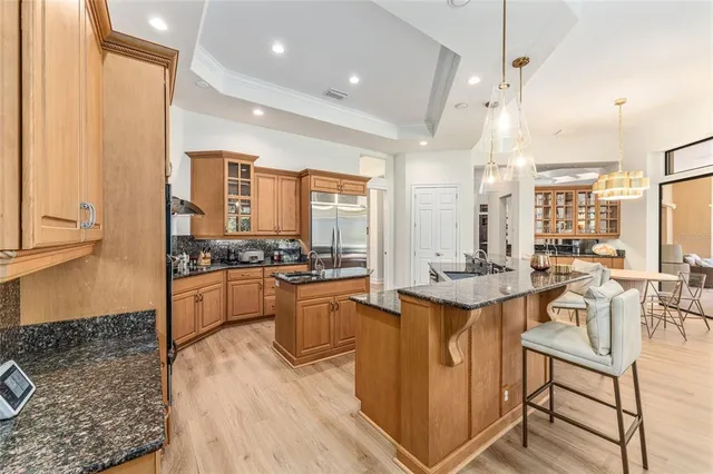 a dining room with wooden floor a chandelier a glass table and chairs