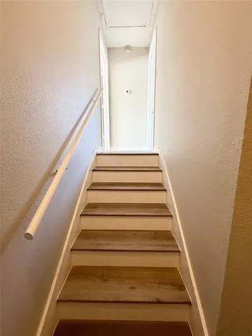 an empty room with wooden floor ceiling fan and windows