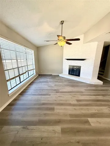 a view of empty room with wooden floor and ceiling fan