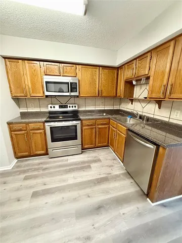a kitchen with stainless steel appliances granite countertop a stove and a sink