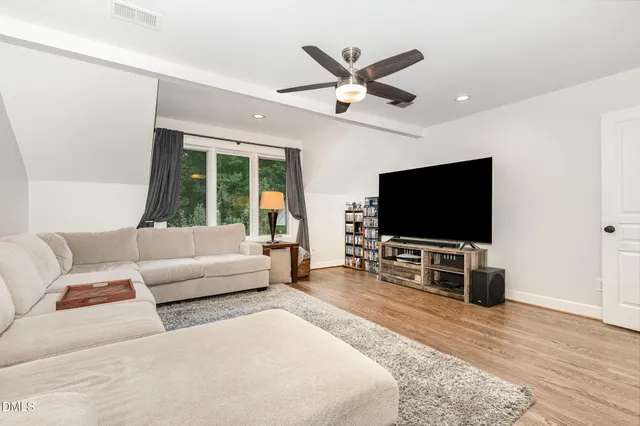 a kitchen with a table chairs stove and wooden floor