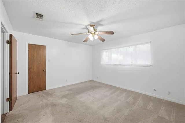 a view of a room with a ceiling fan and a window