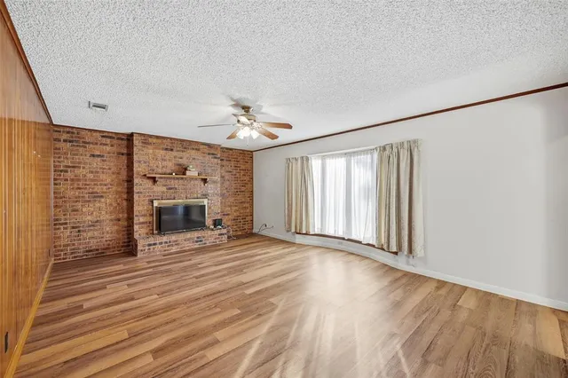 a view of an empty room with a fireplace and a window