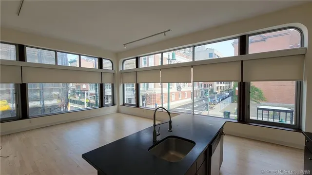 a view of a livingroom with furniture wooden floor windows and a fireplace