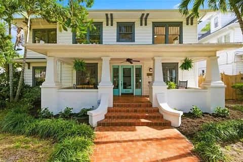a front view of a house with garden and trees
