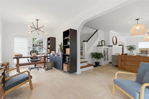 a view of a hallway with wooden floor and staircase