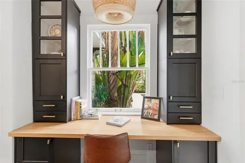 a view of a workspace with furniture and a window