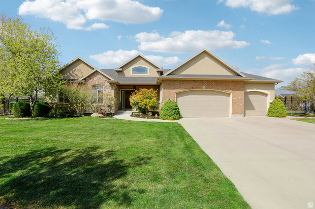 View of front of house with a garage, driveway, and brick siding