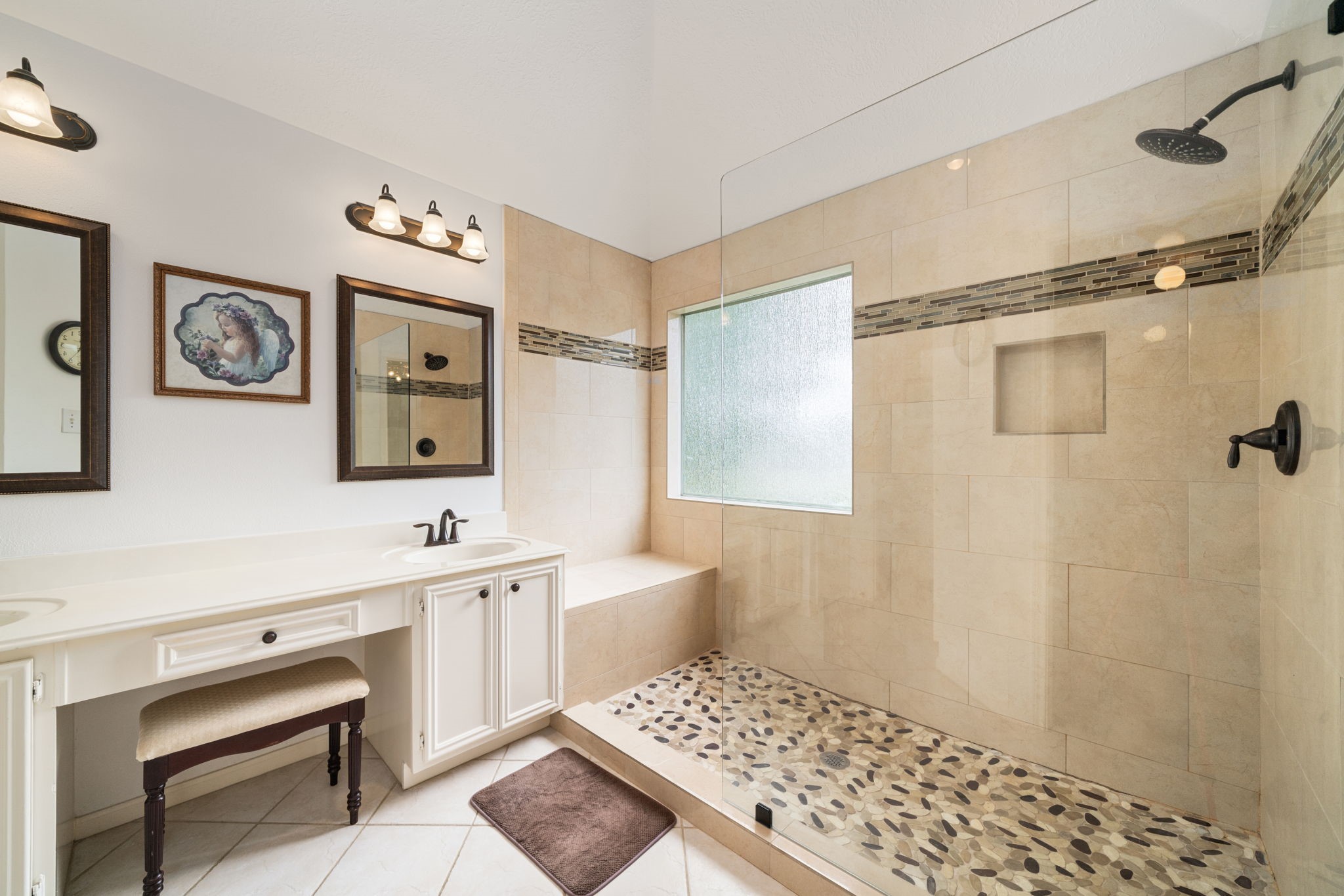 9715 Therrell Drive Houston, TX 77064 - Photo 20 of 33 Updated primary bath featuring a spacious walk-in shower, decorative tile flooring, glass tile accent border, built-in niche, and a tile bench.