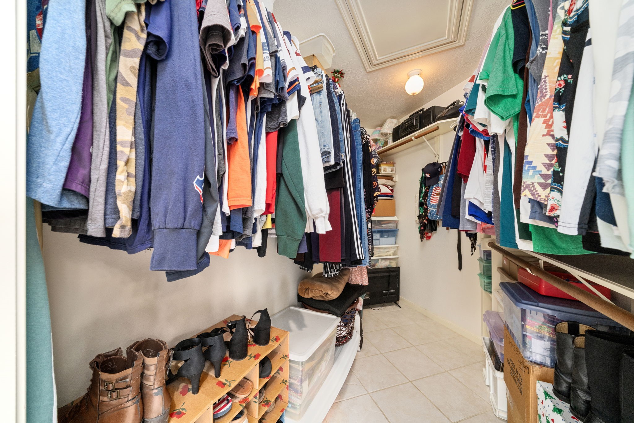 9715 Therrell Drive Houston, TX 77064 - Photo 22 of 33 Spacious walk-in closet with dual hanging rods on both sides, upper shelving, and tile flooring offering ample storage for the whole wardrobe.