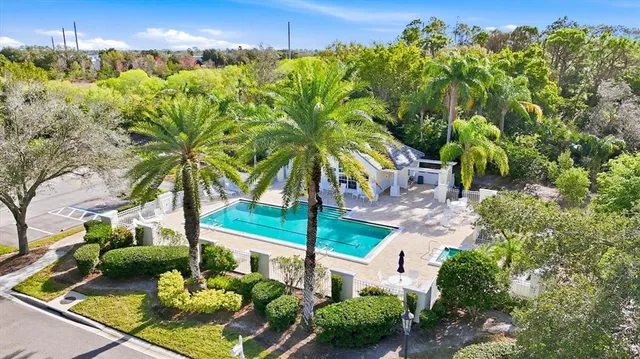 a view of a big house with table and chairs under an umbrella