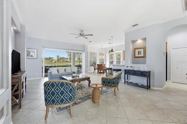 a living room with furniture a flat screen tv and a large window
