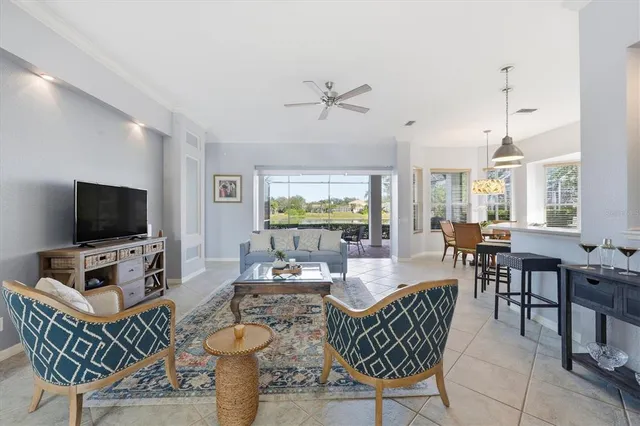 a living room with furniture and a flat screen tv with kitchen view