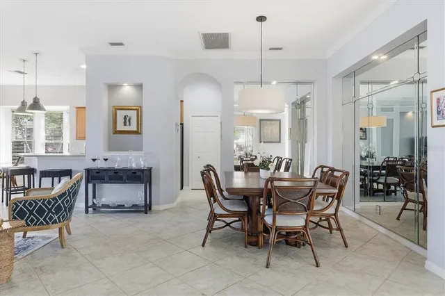 a kitchen with stainless steel appliances kitchen island granite countertop a table chairs in it and wooden floors