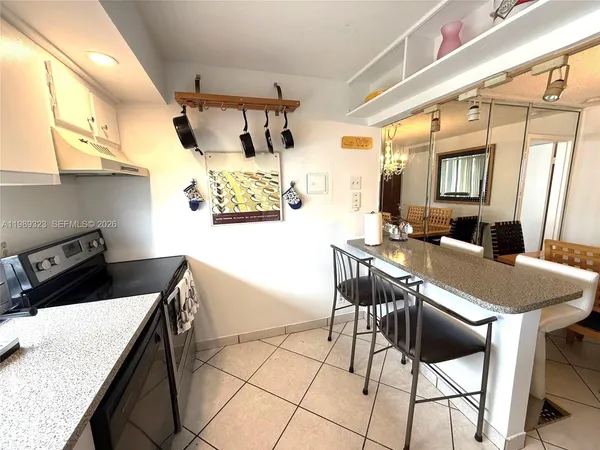a kitchen with stainless steel appliances granite countertop a stove a refrigerator a dining table and chairs