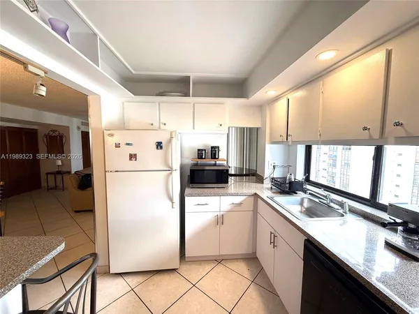a kitchen with a refrigerator a sink and cabinets