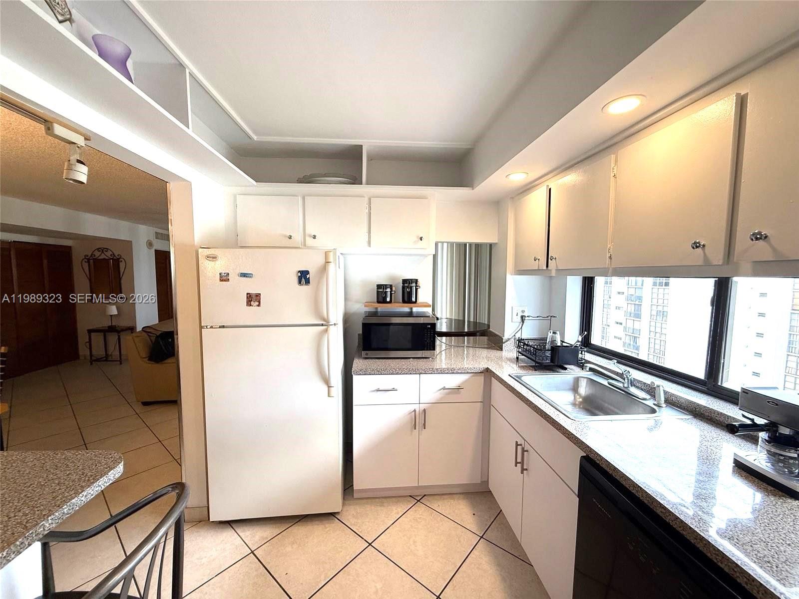 17011 North Bay Road, Unit 1007 Sunny Isles Beach, FL 33160 - Photo 12 of 28 a kitchen with a refrigerator a sink and cabinets