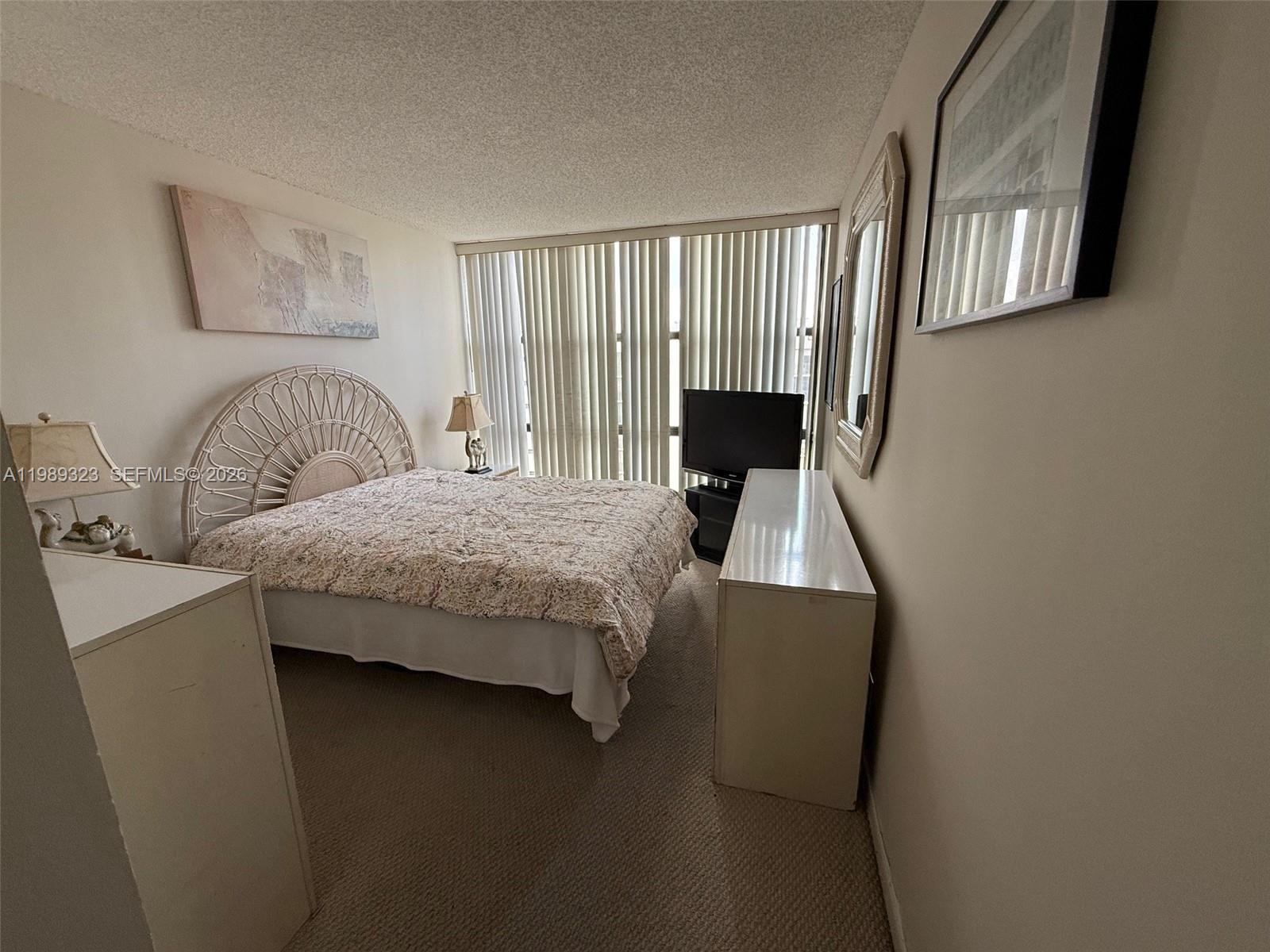 17011 North Bay Road, Unit 1007 Sunny Isles Beach, FL 33160 - Photo 14 of 28 a bedroom with a bed chair and window