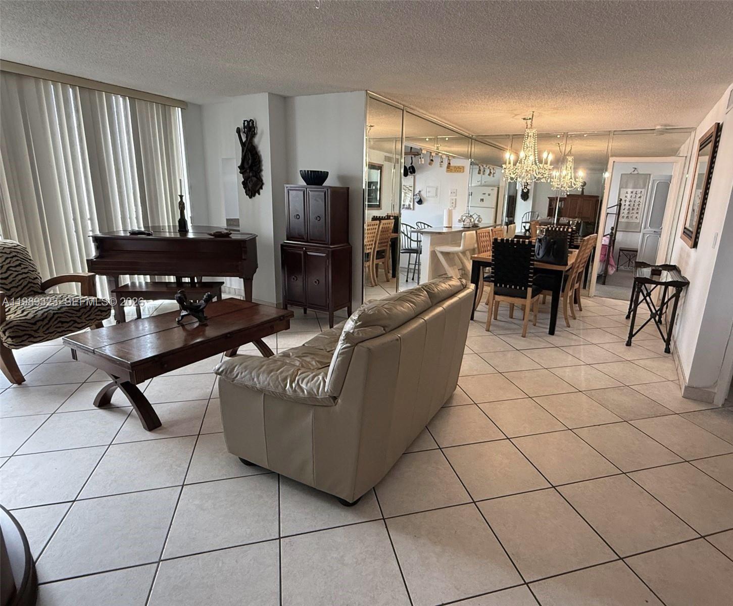 17011 North Bay Road, Unit 1007 Sunny Isles Beach, FL 33160 - Photo 6 of 28 a living room with couches and a dining table with wooden floor