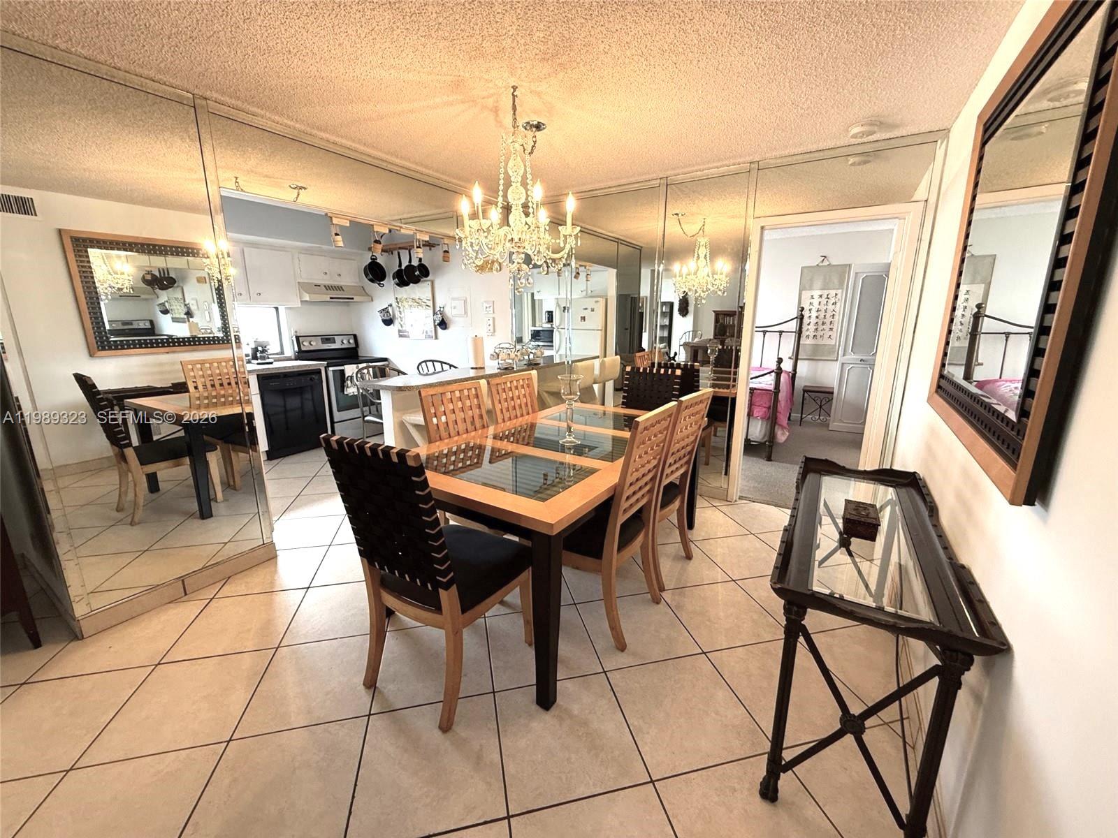 17011 North Bay Road, Unit 1007 Sunny Isles Beach, FL 33160 - Photo 8 of 28 a view of a dining room with furniture and a chandelier