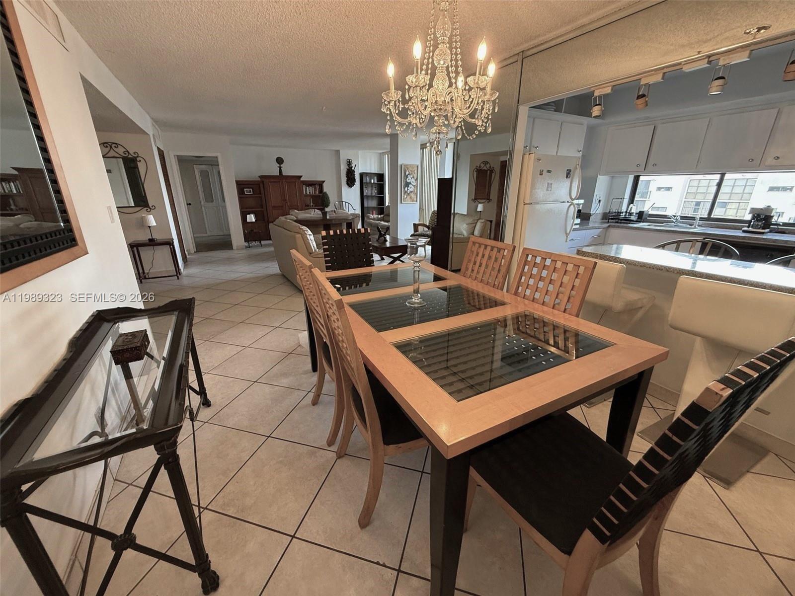 17011 North Bay Road, Unit 1007 Sunny Isles Beach, FL 33160 - Photo 9 of 28 a kitchen that has a table and chairs in it