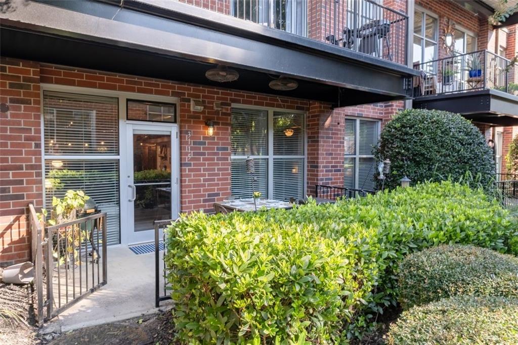 a front view of a building with outdoor seating and plants