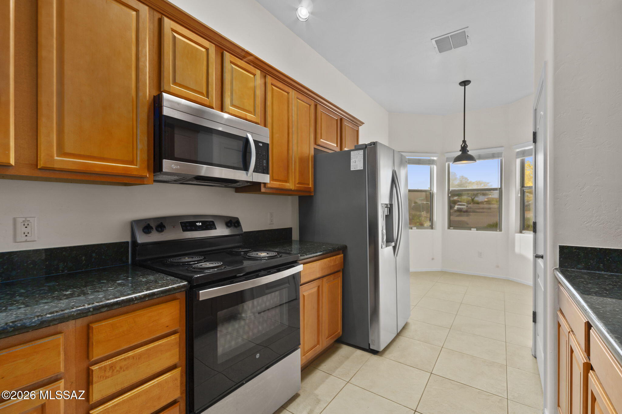 13668 East High Plains Ranch Street Vail, AZ 85641 - Photo 10 of 51 a kitchen with stainless steel appliances granite countertop a stove a refrigerator and a microwave