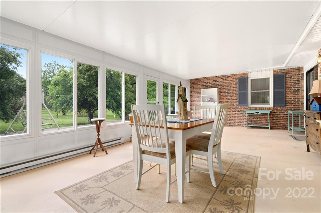 2480 Ridge Road Hendersonville, NC 28792 - Photo 26 of 48 a view of a dining room with furniture large windows and wooden floor