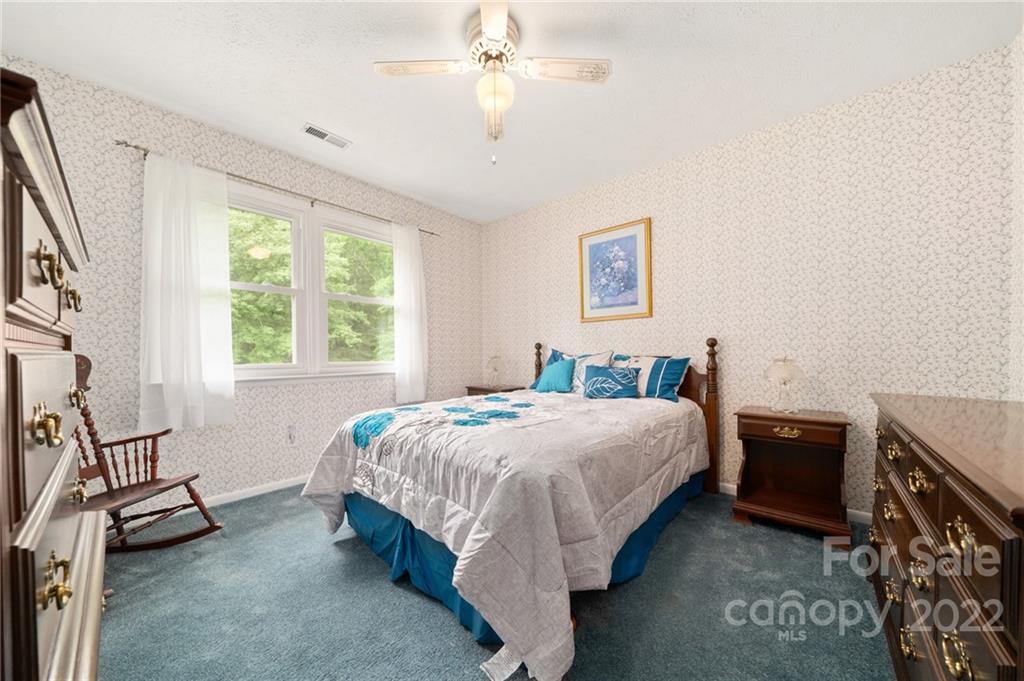 2480 Ridge Road Hendersonville, NC 28792 - Photo 29 of 48 a bedroom with a bed and a chandelier