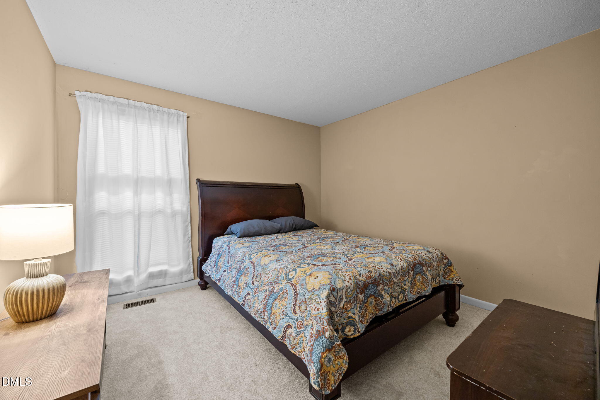 5816 Pointer Drive, Unit 102 Raleigh, NC 27609 - Photo 19 of 25 a bedroom with a bed and a lamp