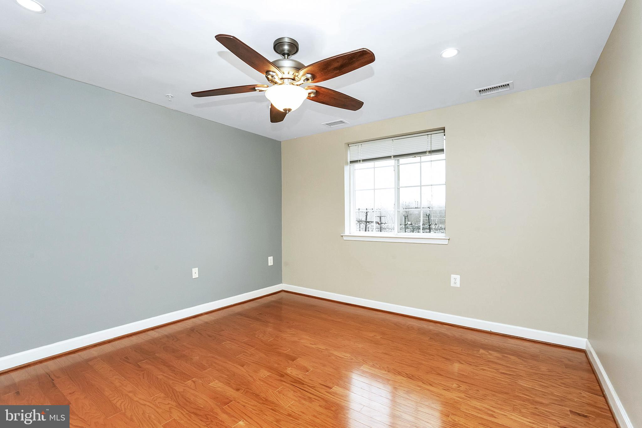 4079 South Four Mile Run Drive, Unit 402 Arlington, VA 22204 - Photo 11 of 30 an empty room with a window and ceiling fan