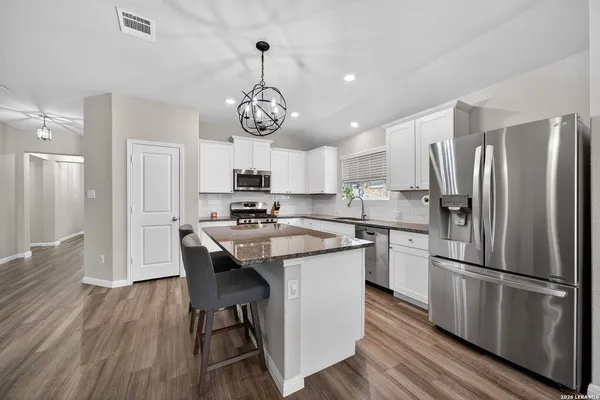 a kitchen with granite countertop a stove oven and white cabinets