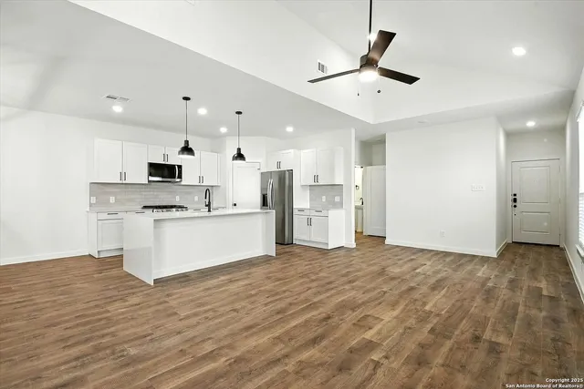 a view of kitchen with stainless steel appliances refrigerator stove microwave and cabinets
