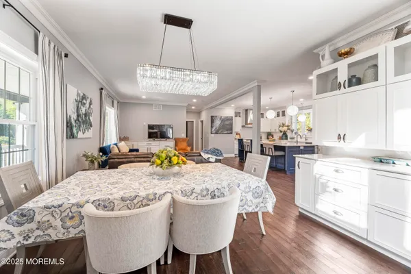 a view of a dining room with furniture a chandelier and wooden floor