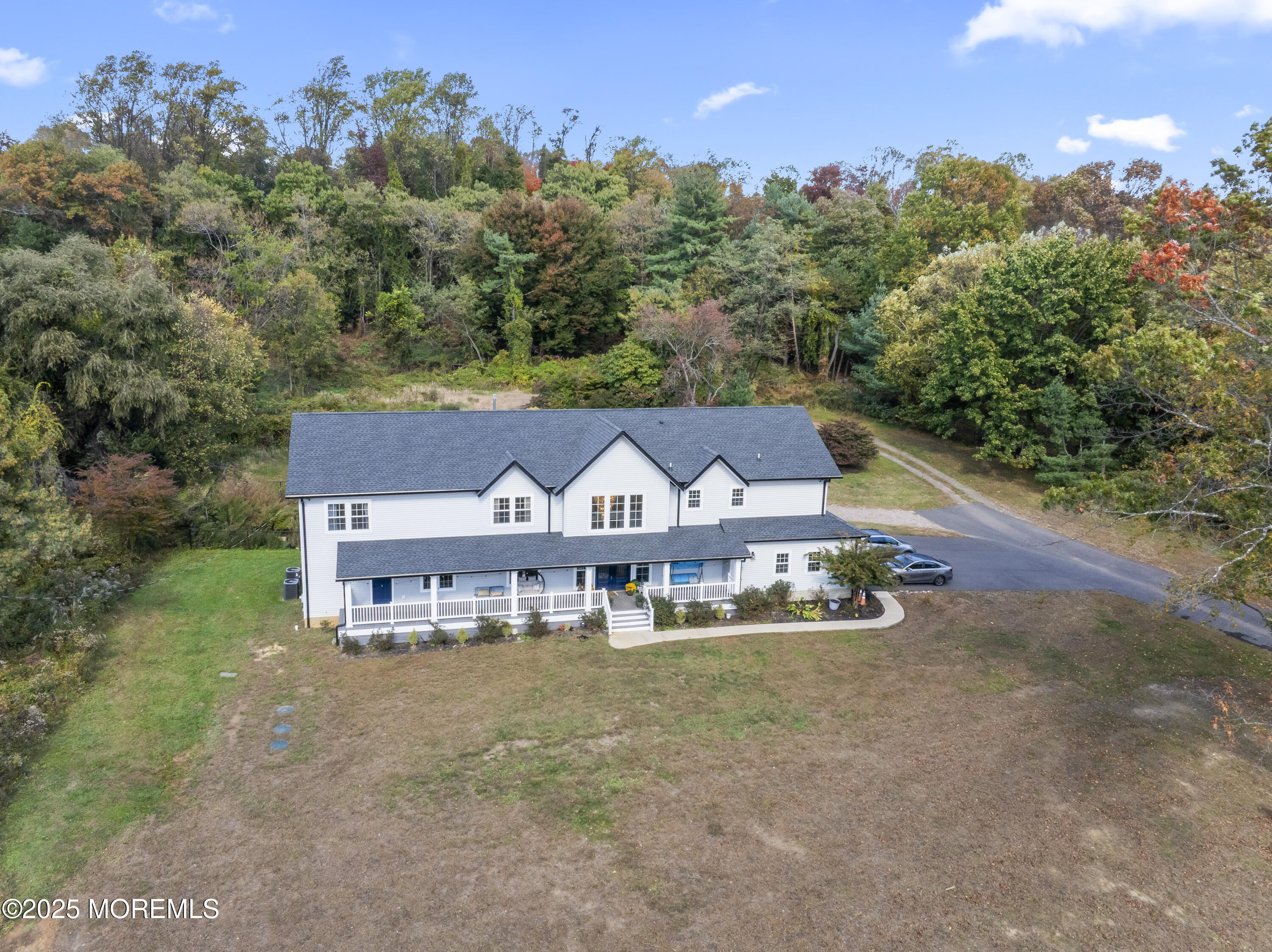 832 Holmdel Road Holmdel, NJ 07733 - Photo 2 of 44 an aerial view of a house with yard and trees in the background