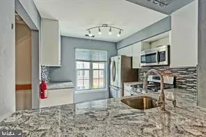 a kitchen with granite countertop a sink and a stove top oven